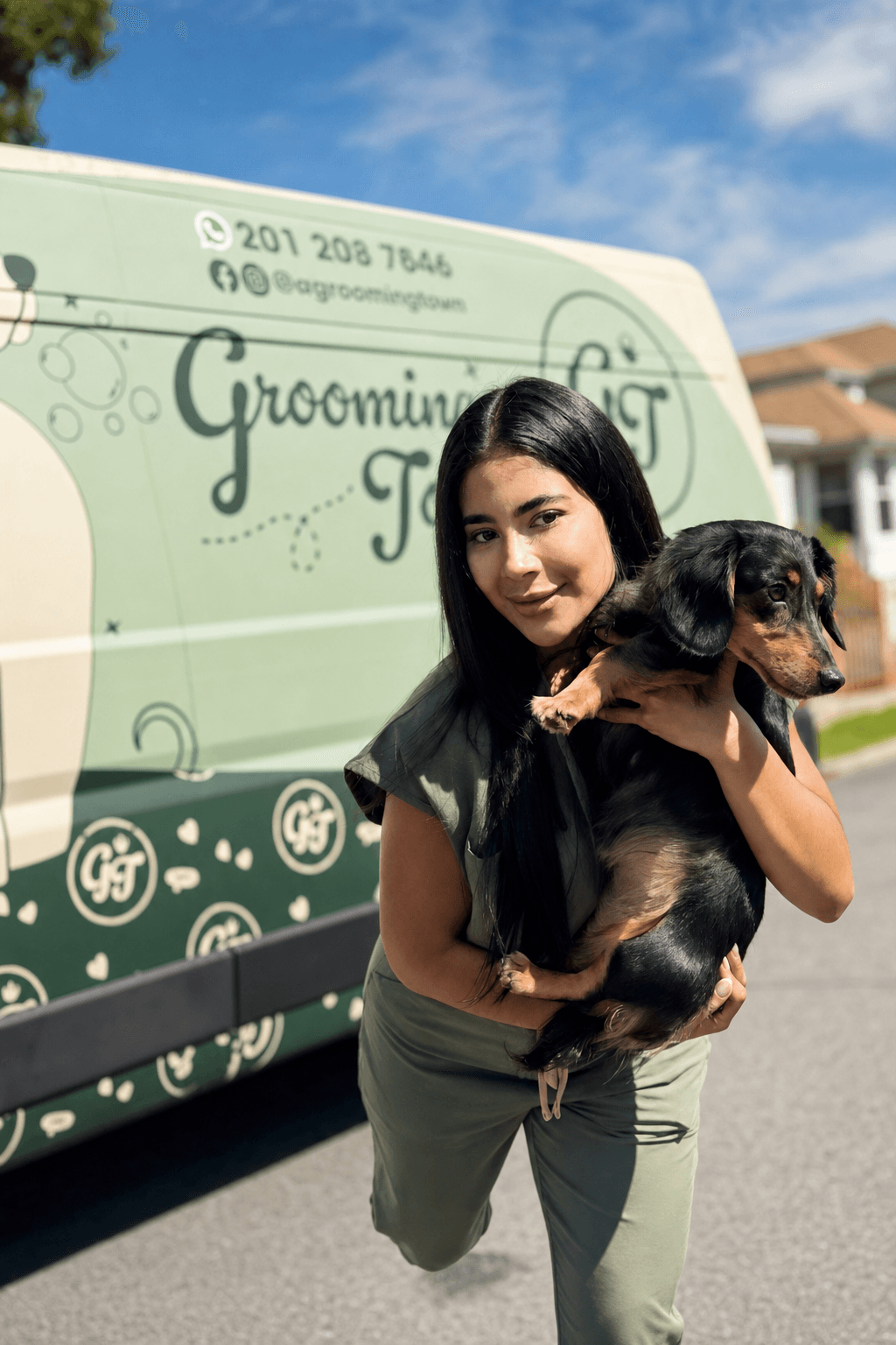 Solmary, founder of Grooming Town, holding a long-haired dachshund